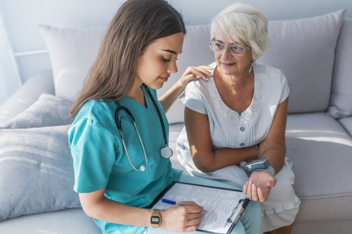 Nurse measuring blood pressure of senior woman